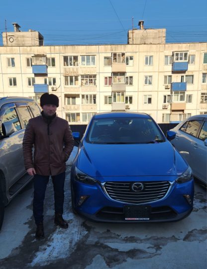 Мужчина рядом с синей Mazda CX-3 на декабрьском фото из переписки